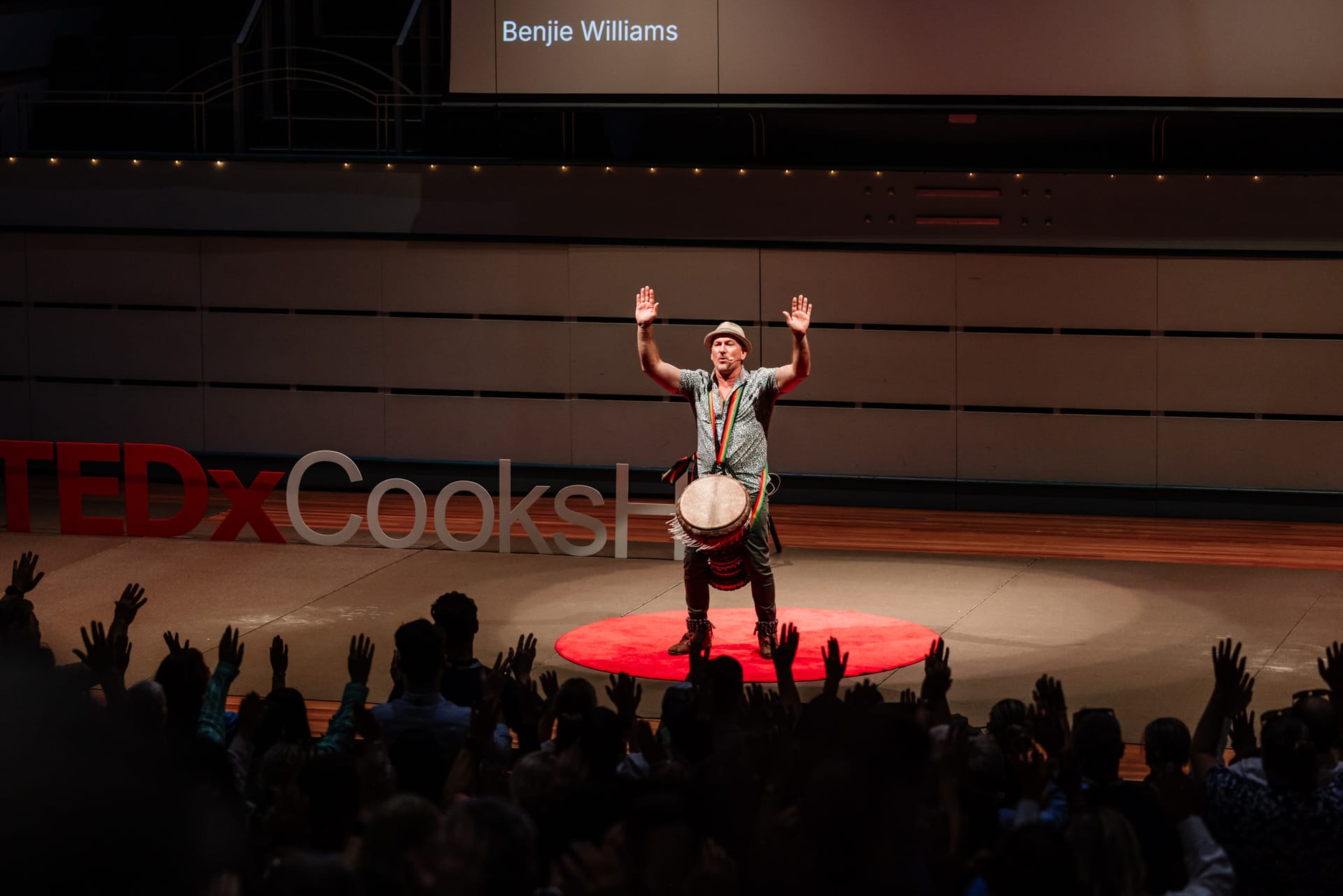 A speaker mid-talk on the TEDxNewy stage